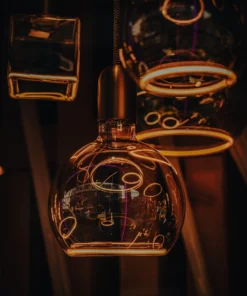 Warm cafe interior with glowing outlines around glass teapots.