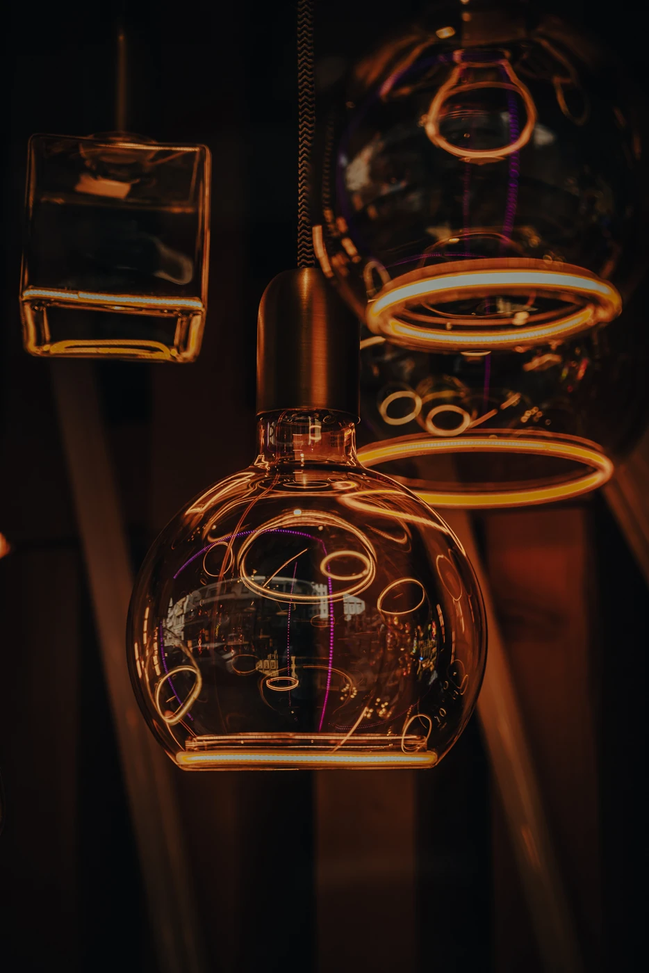 Warm cafe interior with glowing outlines around glass teapots.